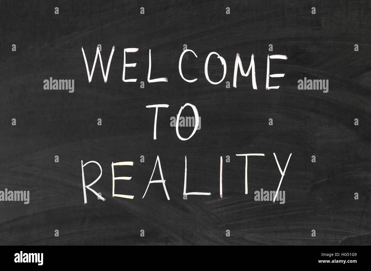 Welcome to reality phrase handwritten on the school blackboard Stock Photo
