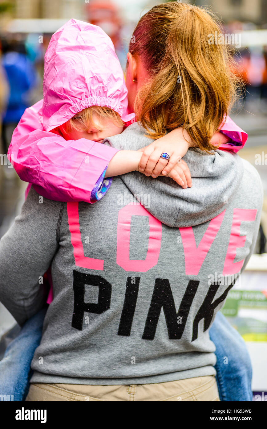 Woman in 'Love Pink' hoodie carries child wearing pink cagoule in Edinburgh  Scotland Stock Photo - Alamy