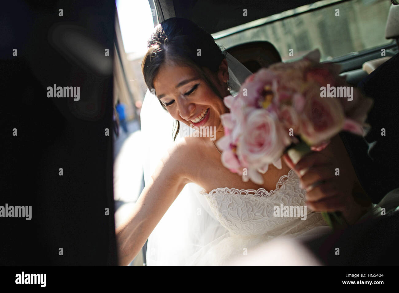 Latin bride arriving to church in wedding car with flower bouquet Stock Photo