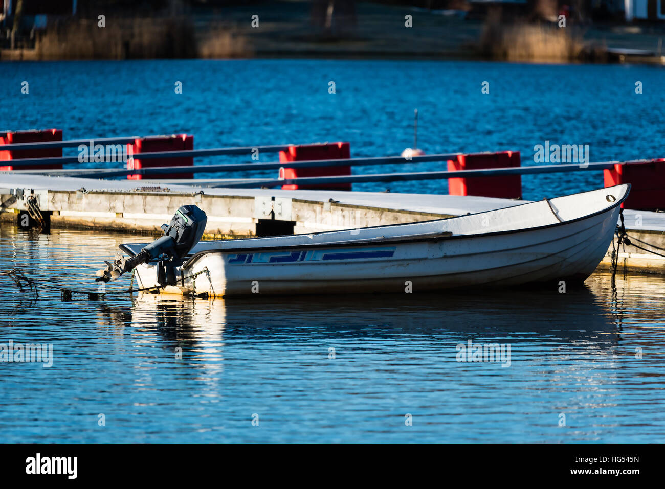 Small motorboat moored alone in the marina Stock Photo
