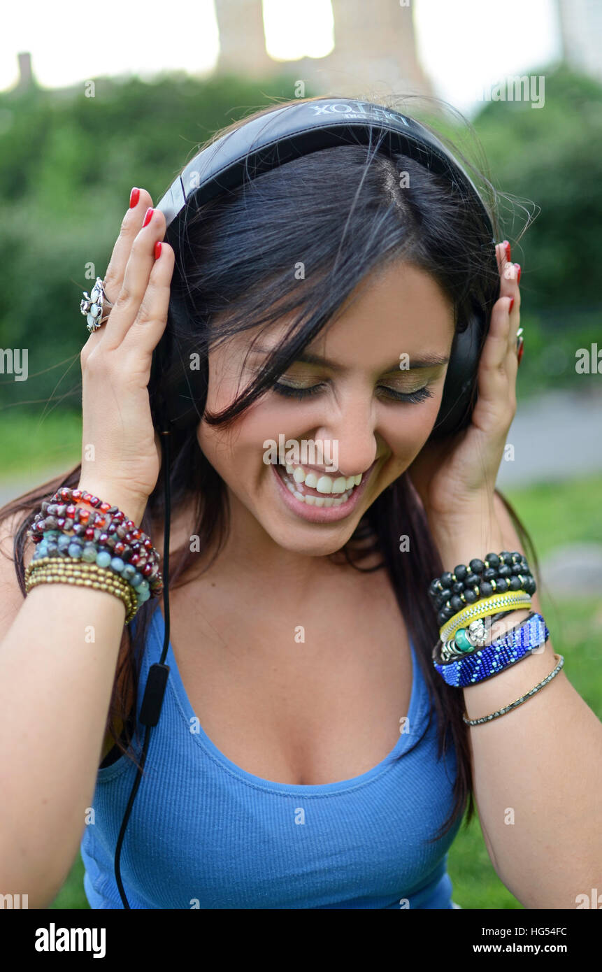 Attractive young mixed race woman listening to music in Central Park, New York City Stock Photo