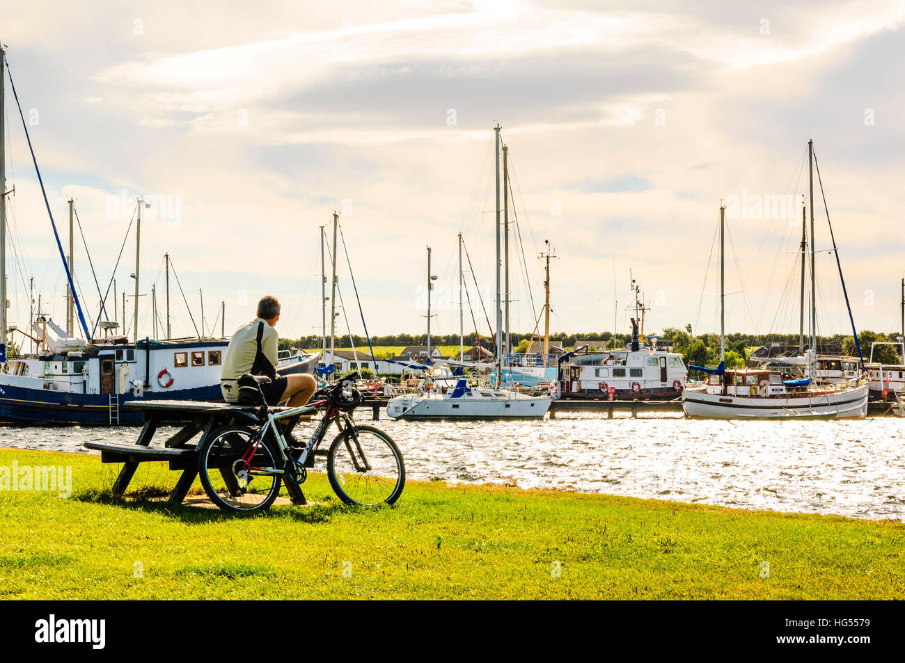 Cyclist taking a break by the inner harbour at Glasson Dock Lancashire Stock Photo