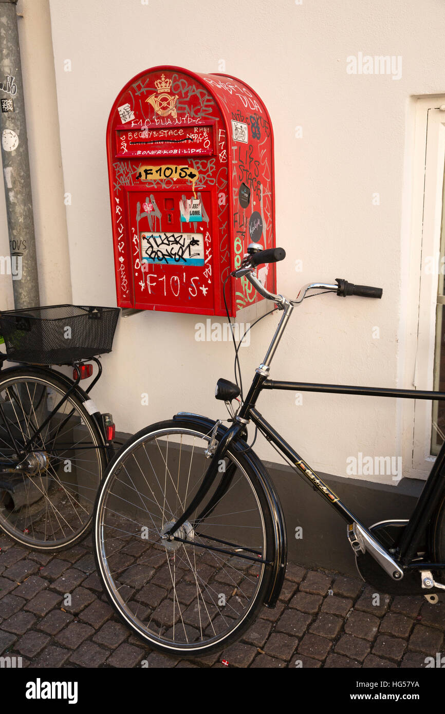 Denmark, Copenhagen, Furtunestraede, bicycle parked next to graffiti covered post box Stock Photo