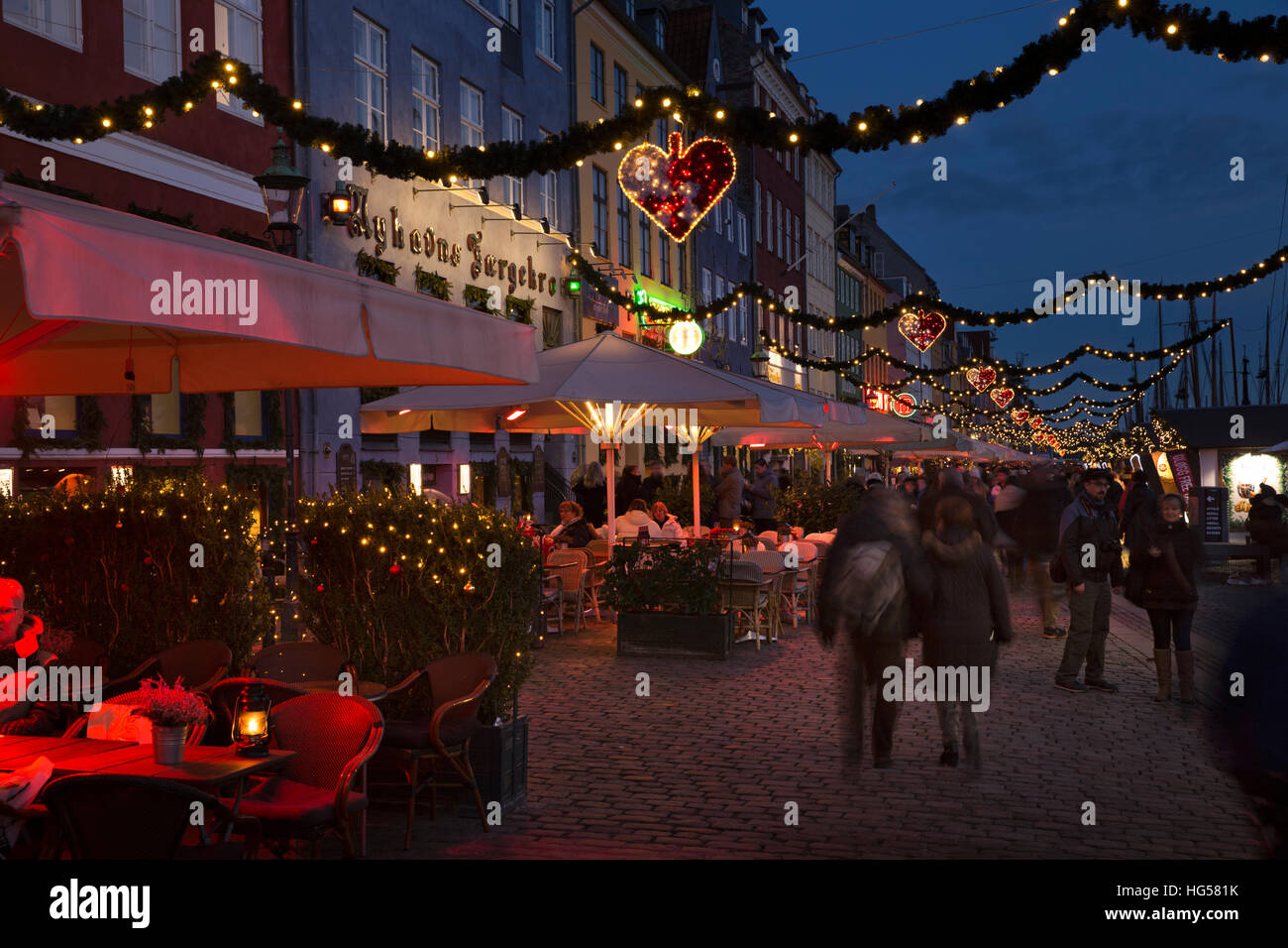 Denmark, Copenhagen, Nyhavn, Christmas market stalls and cafes lining cobbled quayside at night Stock Photo