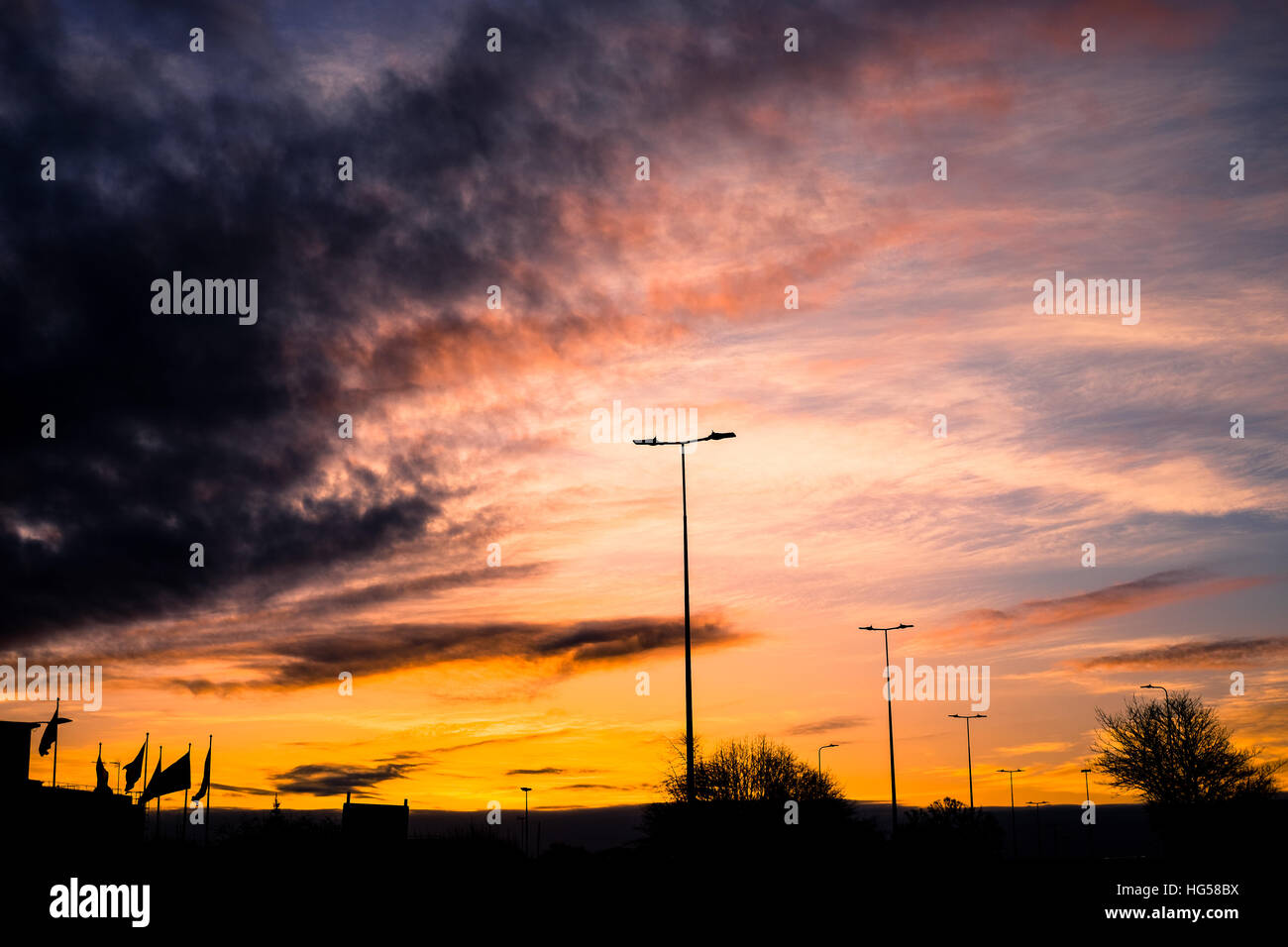 The sun rises over a town as flags blow in the wind Stock Photo