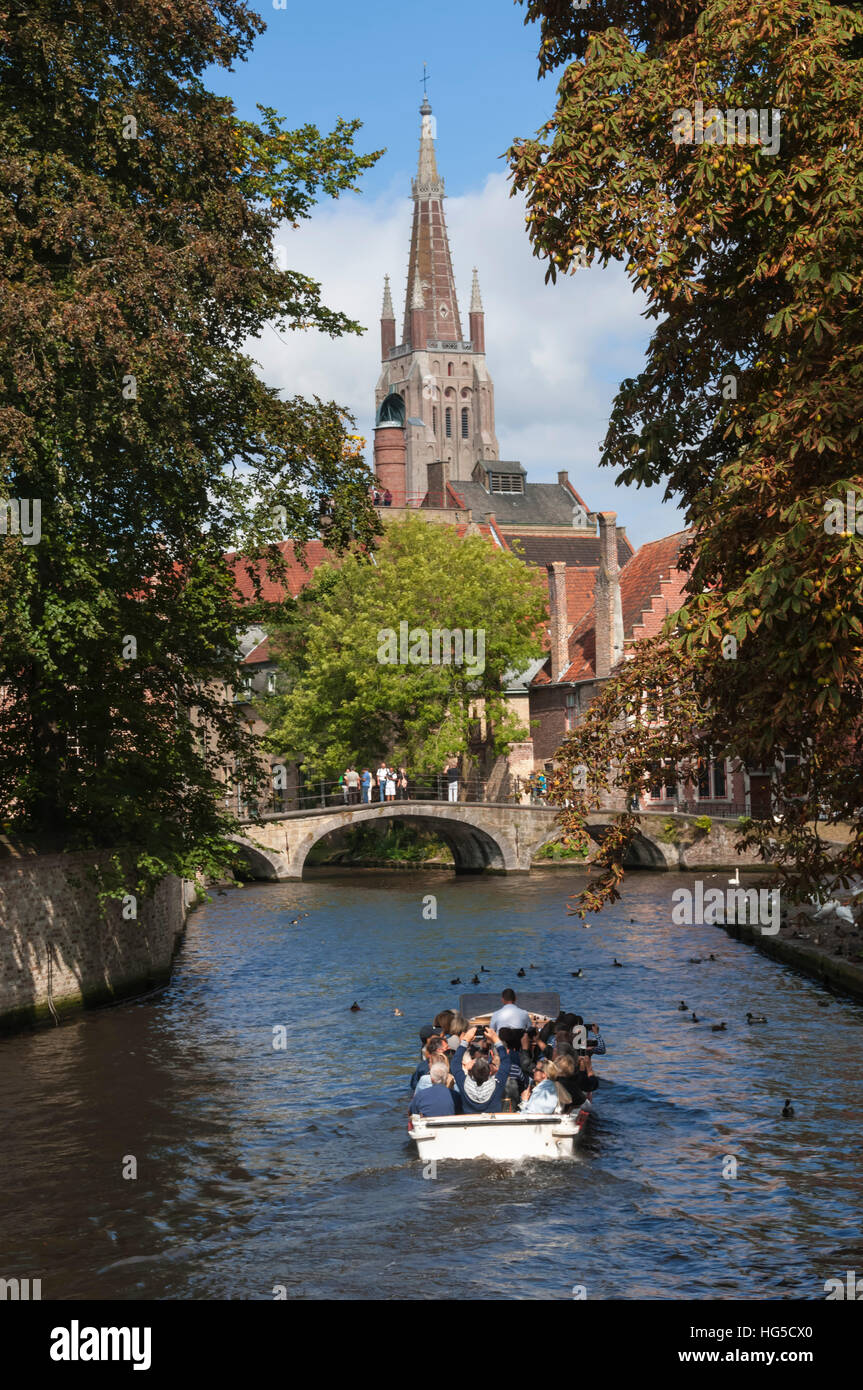 Bridge to Begijnhof, and spire of Church of Our Lady, tourist launch, Bruges, UNESCO, Belgium Stock Photo