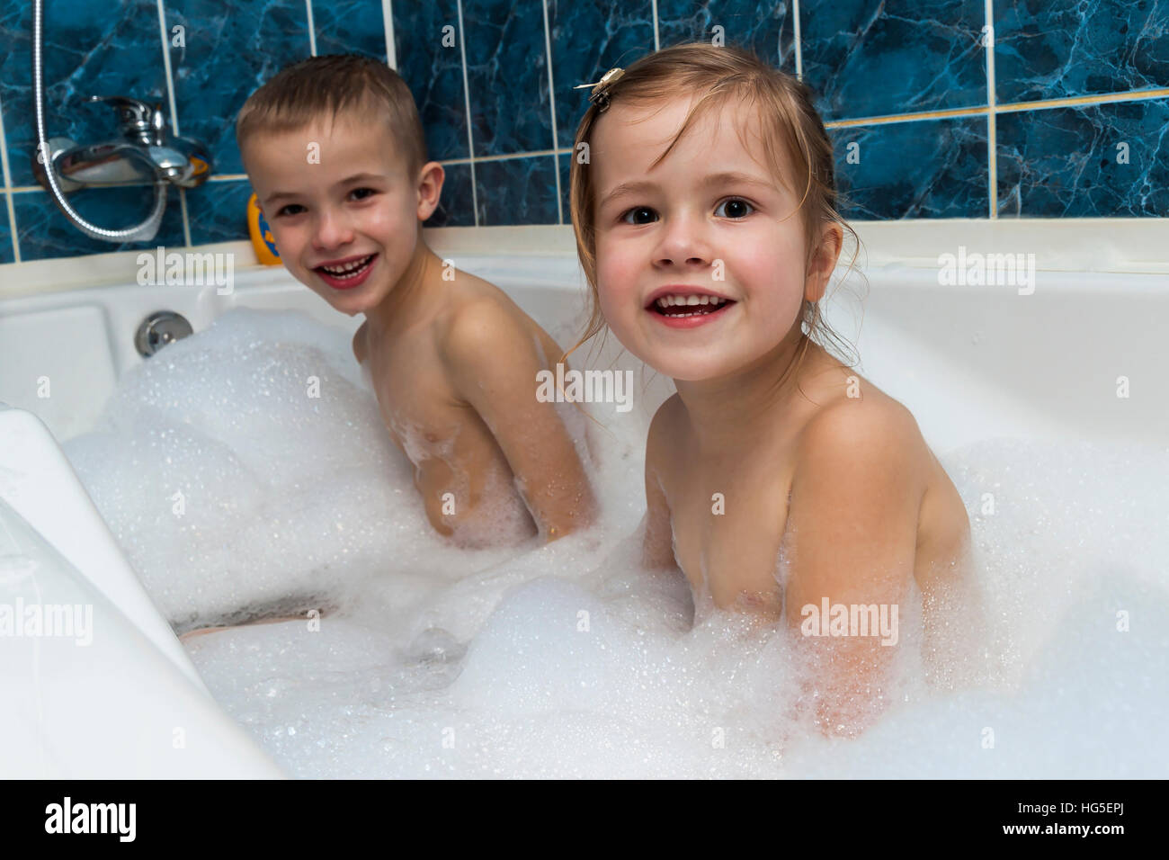 Brother and sister taking a bubble bath. Little boy and girl playing. Healthcare and hygiene concept. Stock Photo