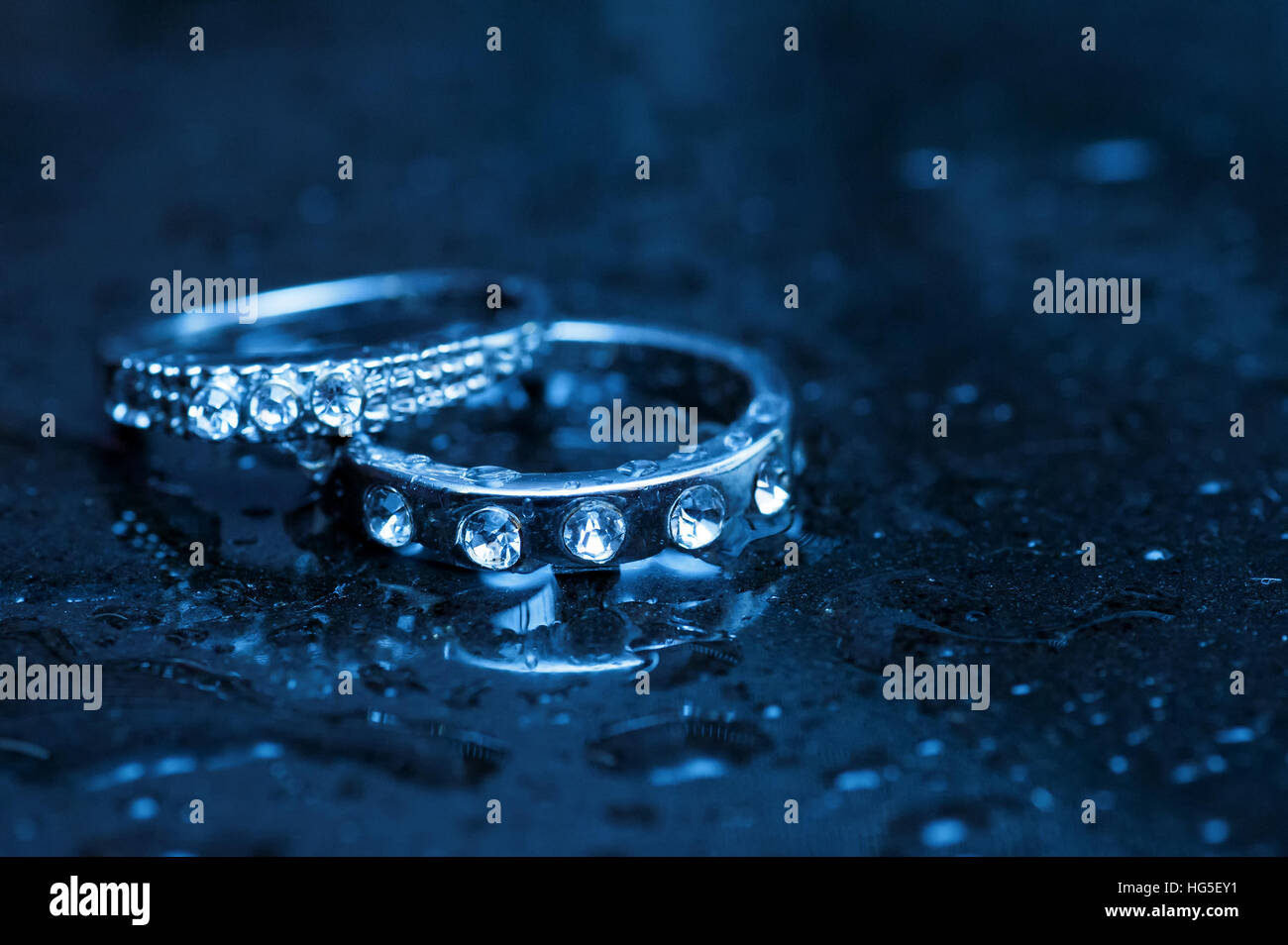 two white gold rings on wet table Stock Photo Alamy