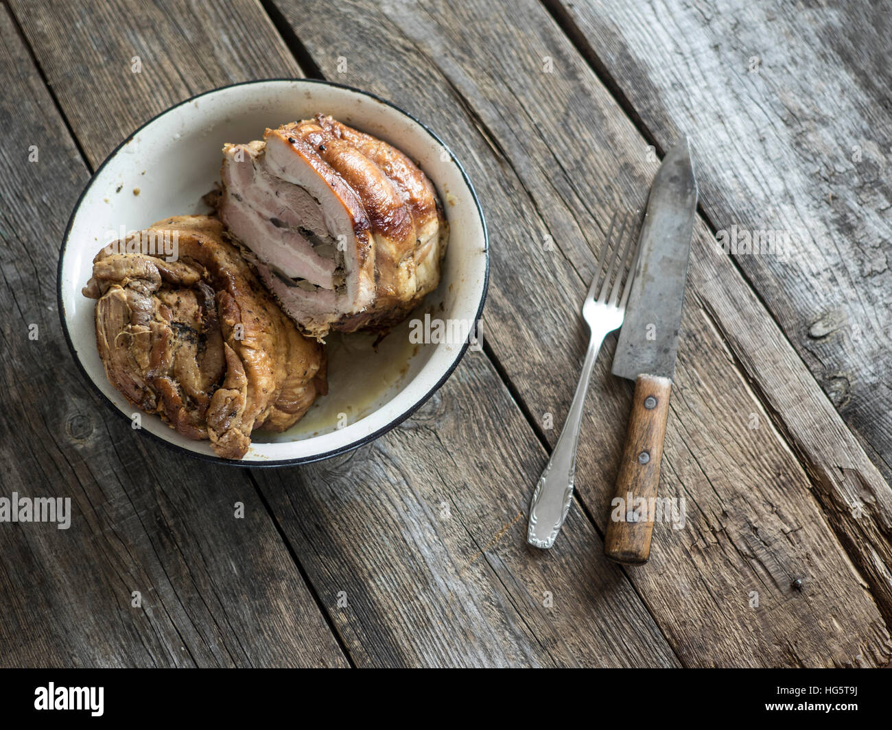 Meatloaf in enameled metal bowl on an old weathered wooden table. Selective focus Stock Photo