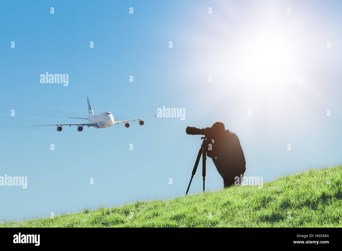 Silhouette of spotter photographer capturing photos of landing airliner. Aircraft or plane spotting is a hobby Stock Photo