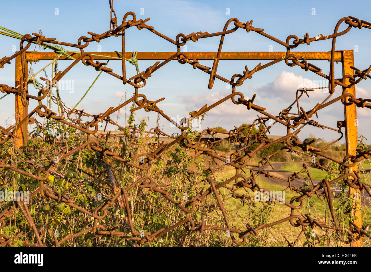 Old farm equipment, rusted and abandoned and used as a fence. Took this shot whilst walking over farmland in Essex. Stock Photo