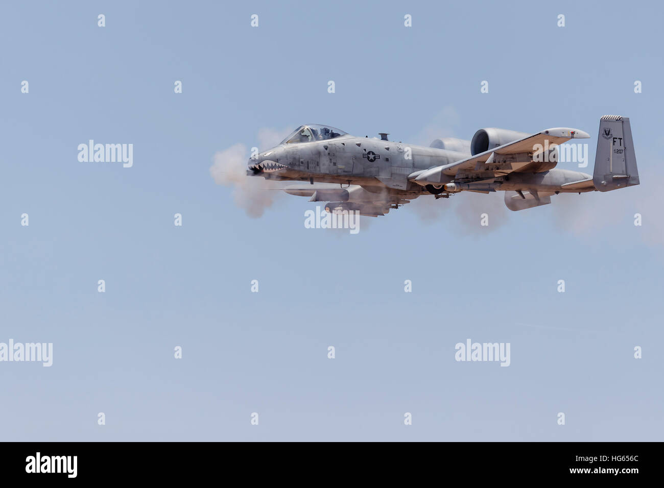 A U.S. Air Force A-10 Thunderbolt II fires its 30mm gun at a strafe target. Stock Photo
