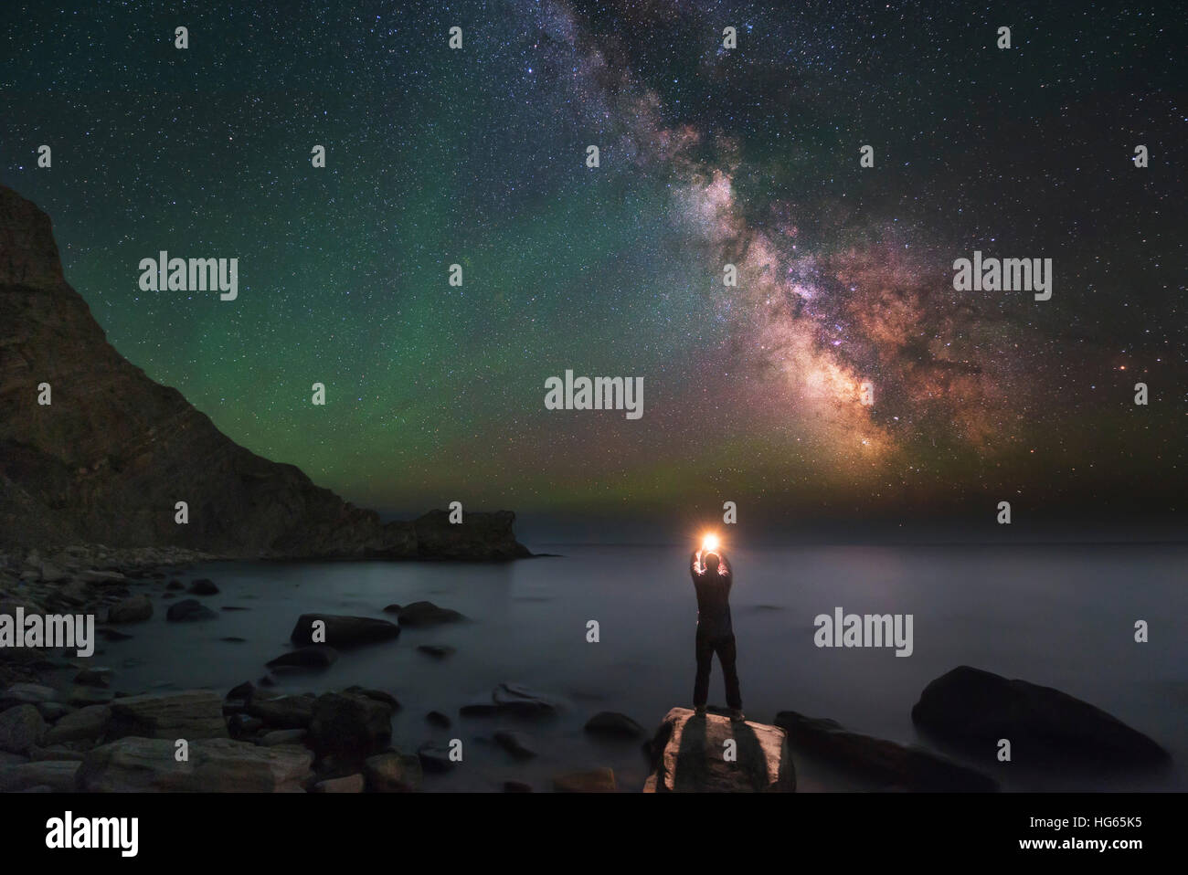 A man stands on the shore of the Black Sea at night under Milky Way. Stock Photo