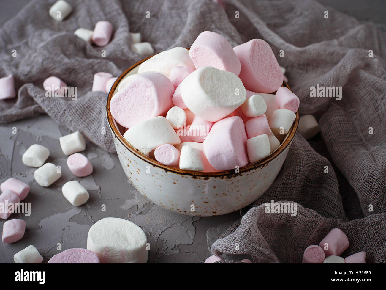 White and pink marshmallows on gray concrete background. Selective focus Stock Photo
