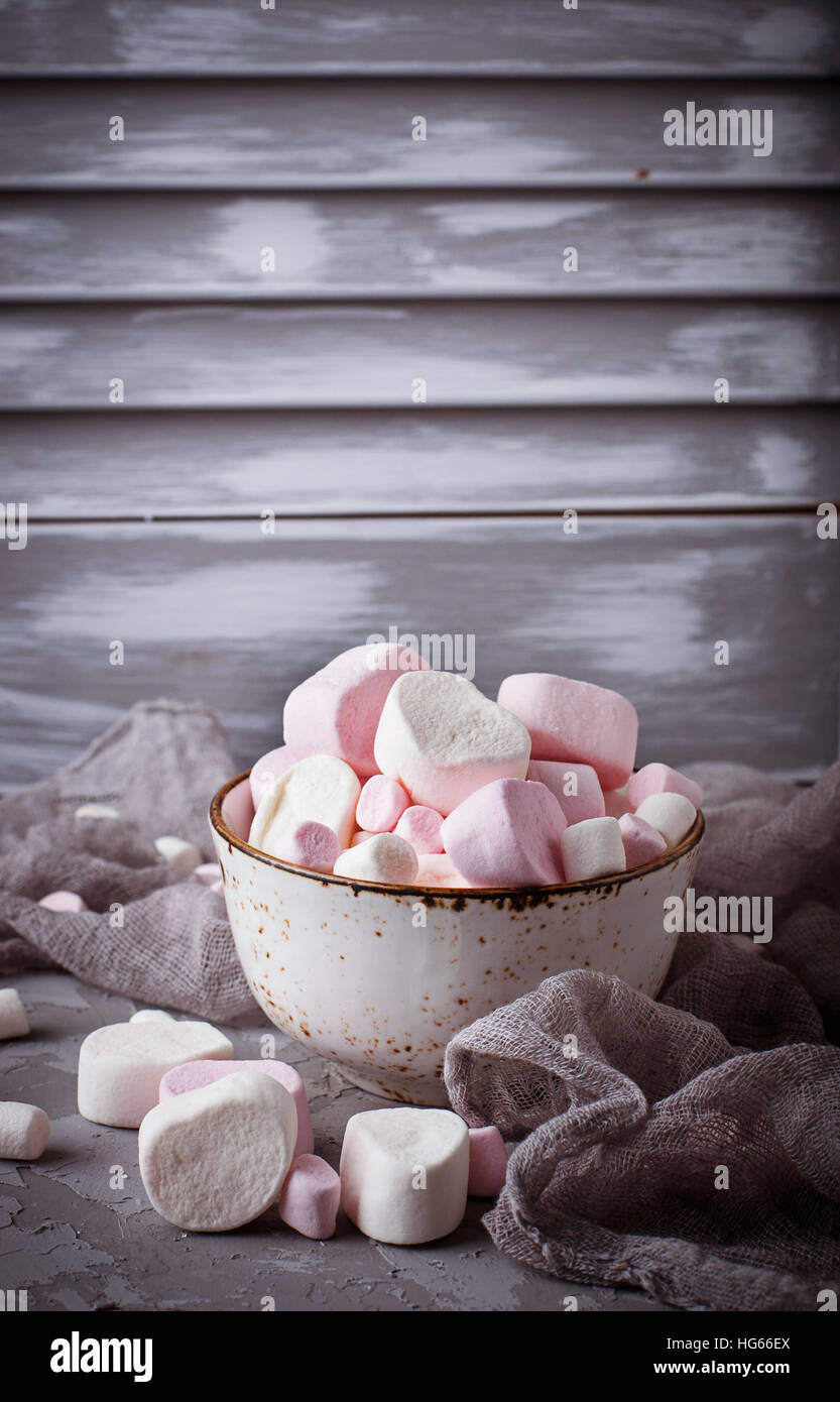 White and pink marshmallows on gray concrete background. Selective focus Stock Photo