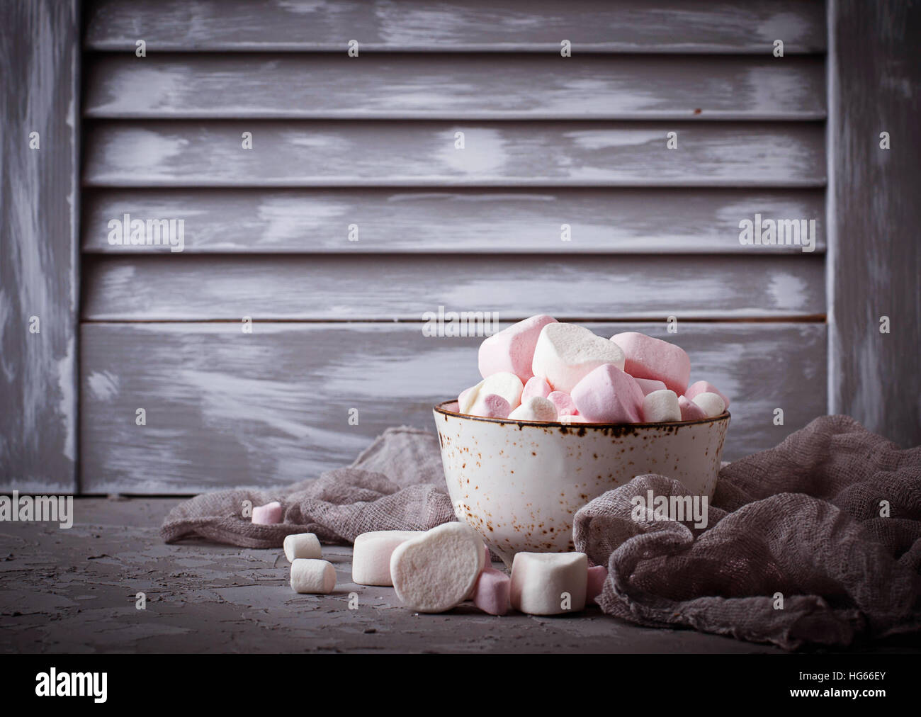 White and pink marshmallows on gray concrete background. Selective focus Stock Photo