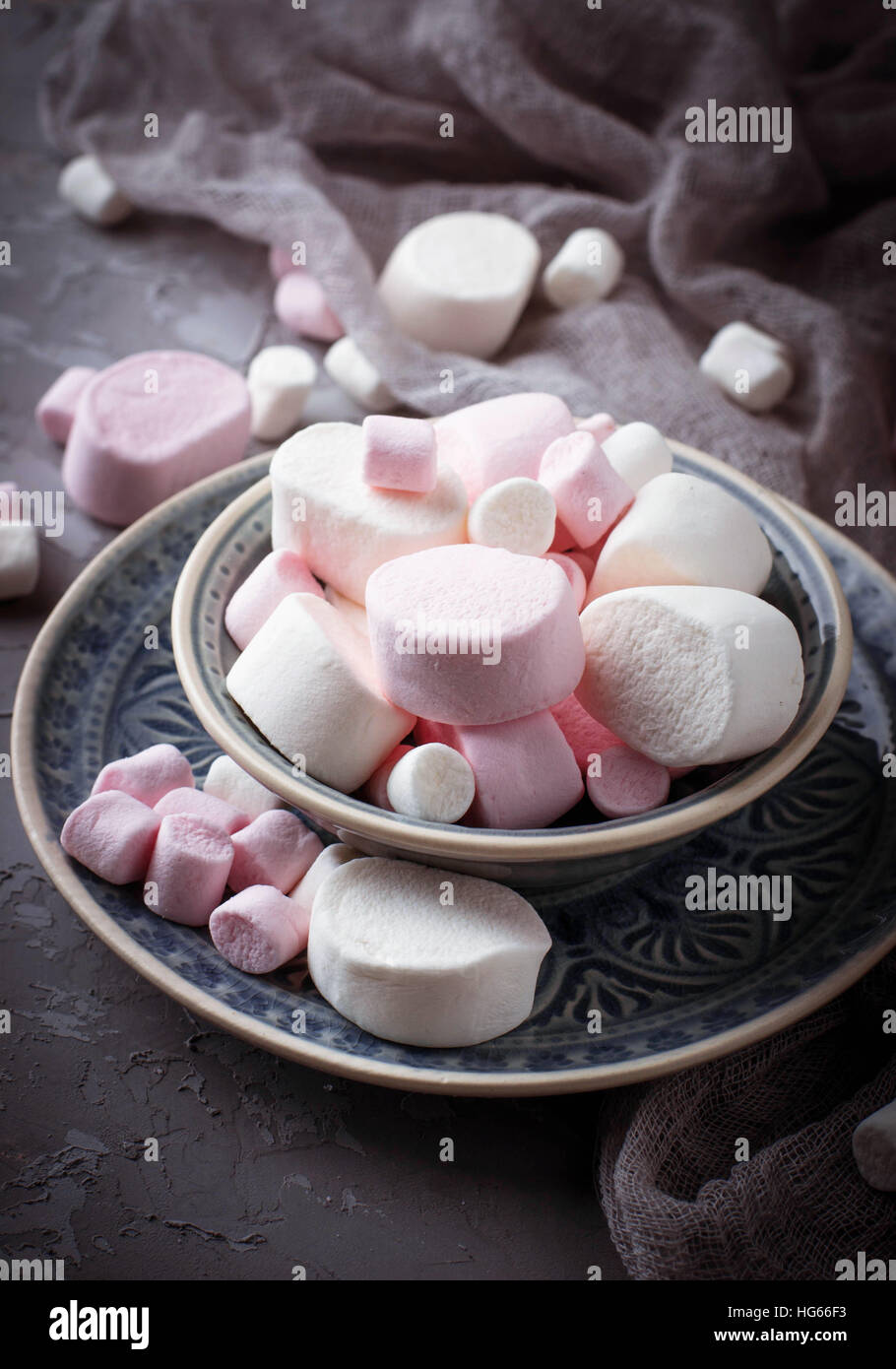 White and pink marshmallows on gray concrete background. Selective focus Stock Photo