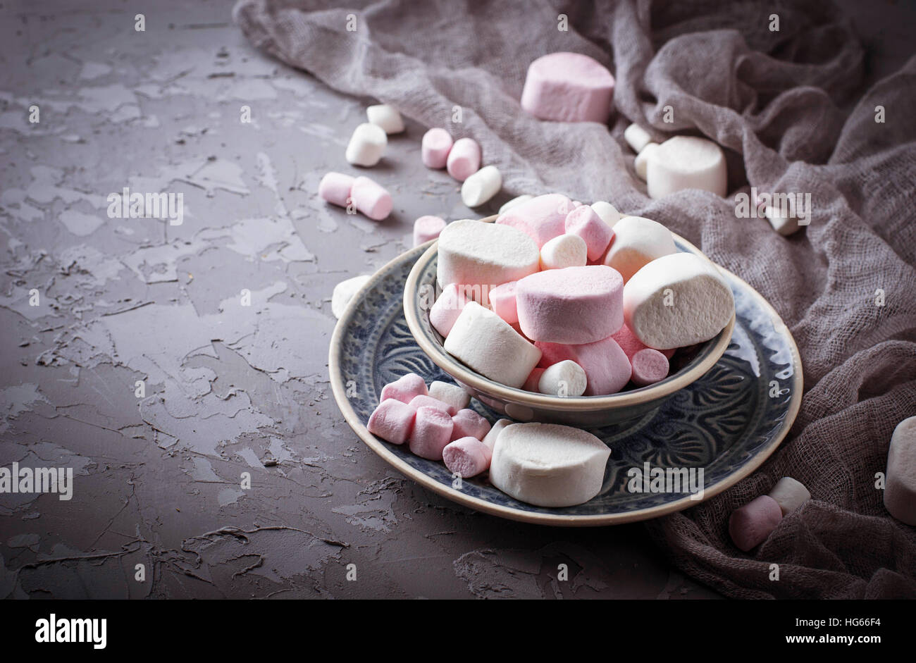 White and pink marshmallows on gray concrete background. Selective focus Stock Photo