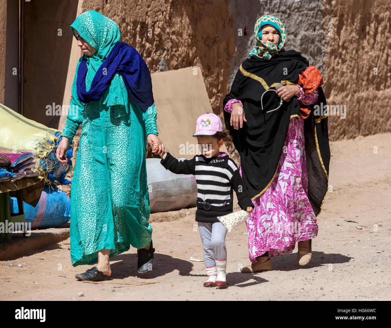 Elkhorbat, Morocco.  Berber Women and Young Girl Walking in the Market. Stock Photo