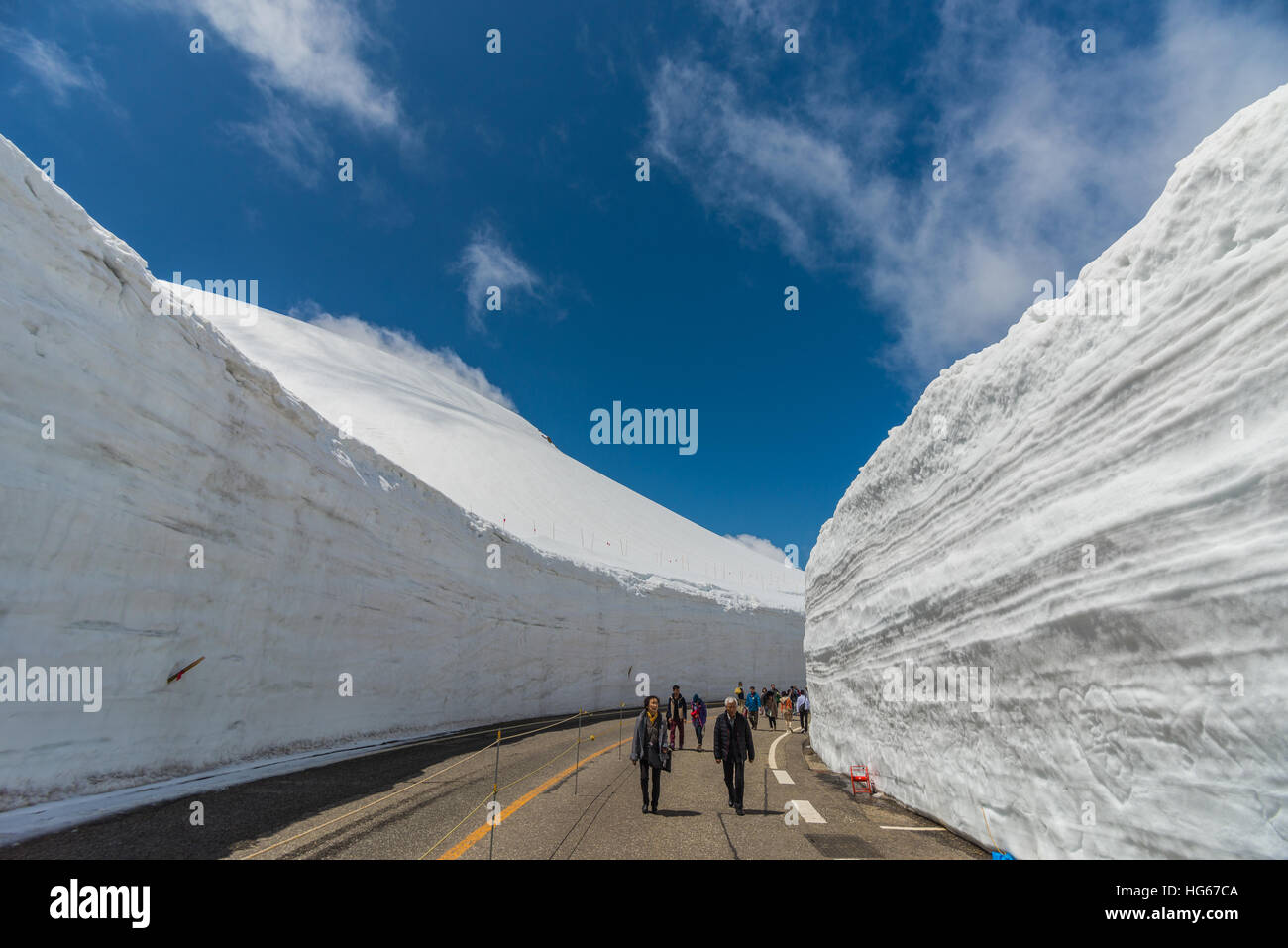 Tateyama, Japan - May 2, 2014: Unidentified tourists  walk along snow corridor on Tateyama Kurobe Alpine Route,  Japanese Alp in Tateyama, Japan Stock Photo