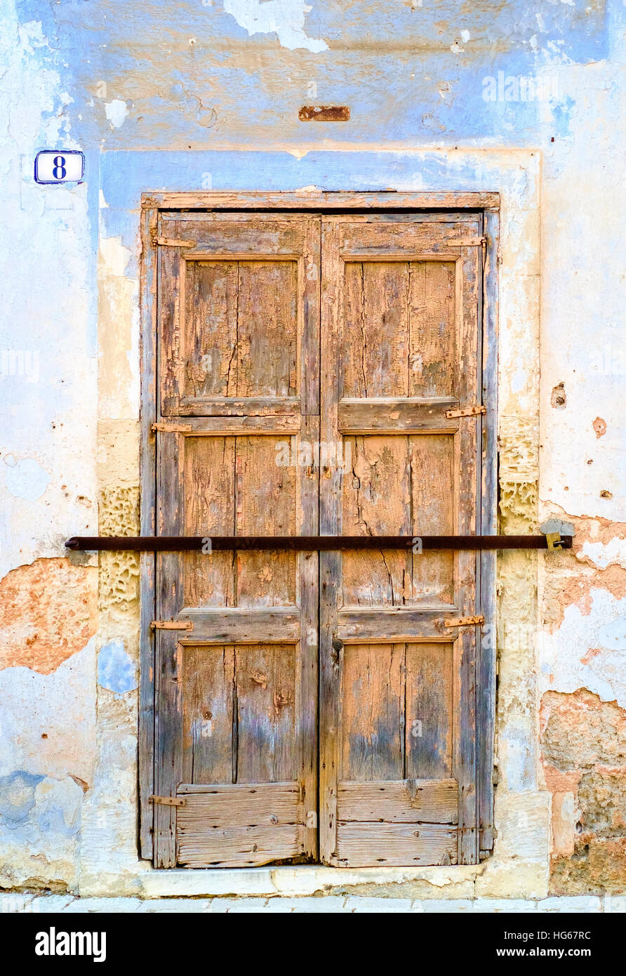 old wooden door locked with iron bar Stock Photo