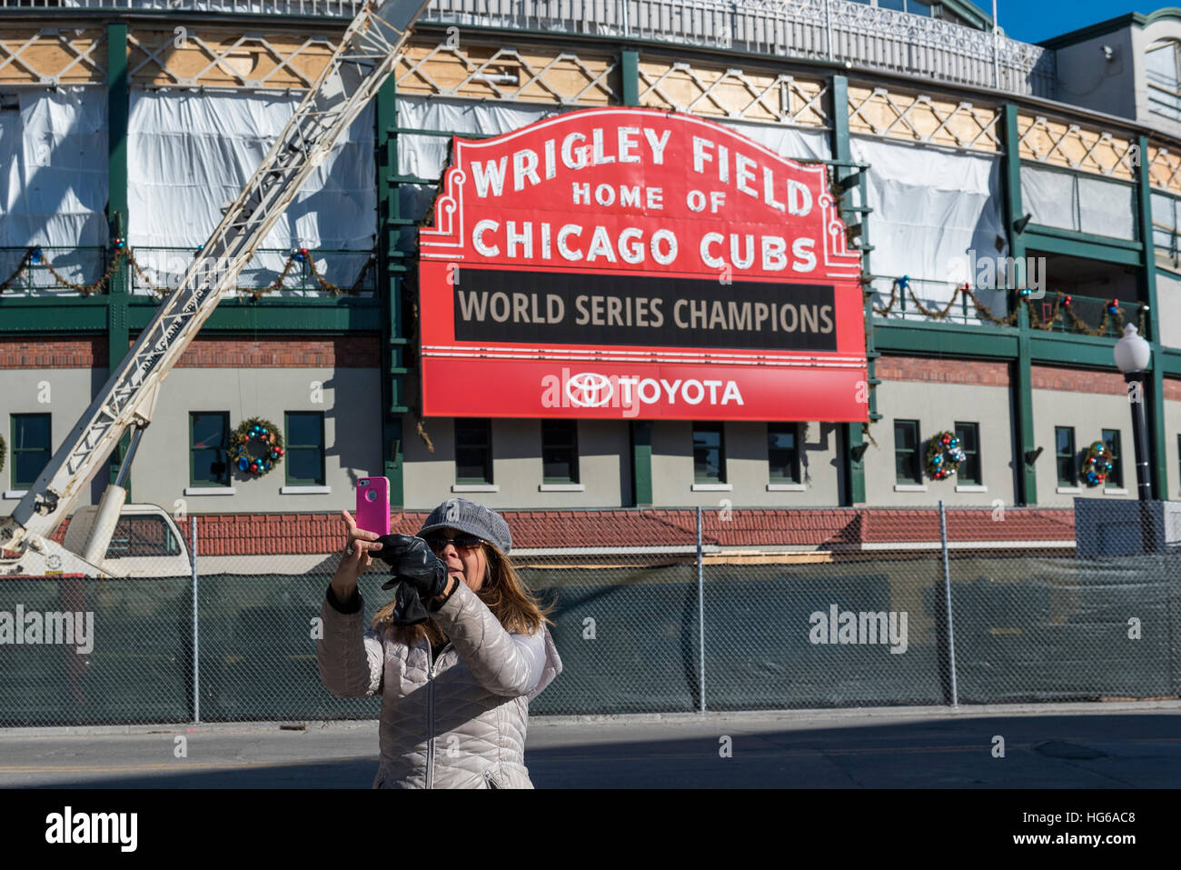 Chicago, USA. 4th Jan, 2017. A tourist takes a selfie at Wrigley Field, the home of baseball's Chicago Cubs, and current World Series Champions, which is currrently undergoing refurbishment and reconstruction. Works include construction of The Hotel Zachary as well as a new retail/entertainment complex at Addison & Clark. © Stephen Chung/Alamy Live News Stock Photo