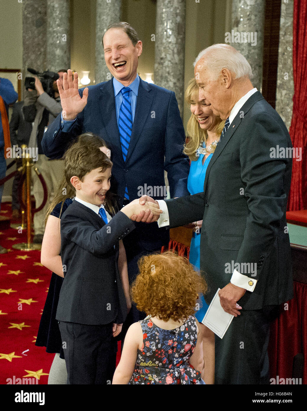 United States Vice President Joe Biden, right, shakes hands with Peter Wyden, who imitated his Dad, US Senator Ron Wyden (Democrat of Oregon) taking the oath of office, center, following a mock swearing-in ceremony in the Old US Senate Chamber in the US Capitol in Washington, DC on Tuesday, January 3, 2017. Also pictured are Wyden's wife, Nancy Bass Wyden and daughters Ava Rose Wyden and Scarlett Willa Wyden. Credit: Ron Sachs/CNP (RESTRICTION: NO New York or New Jersey Newspapers or newspapers within a 75 mile radius of New York City) - NO WIRE SERVICE Foto: Ron Sachs/Consolidated News Pho Stock Photo