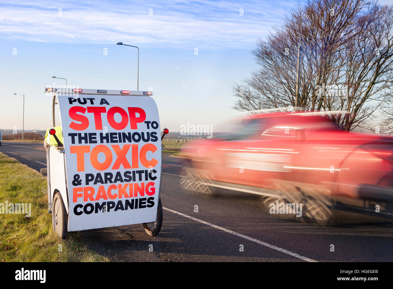 Traffic passing anti-fracking signs in Little Plumpton, Lancashire, UK. 5th Jan 2017. Security moves into the heavily protected area of Little Plumpton, a site designated for the installation of four wells for shale gas extraction by the notorious 'Fracking'. Protesters claim this fracturing process is linked to water pollution, ill health and earthquakes. This controversial Cuadrilla 'Fracking' site was approved on appeal by Communities Secretary Sajid Javid in early December 2016, overturning Lancashire County Councils previous refusal. © Cernan Elias/Alamy Live News Stock Photo