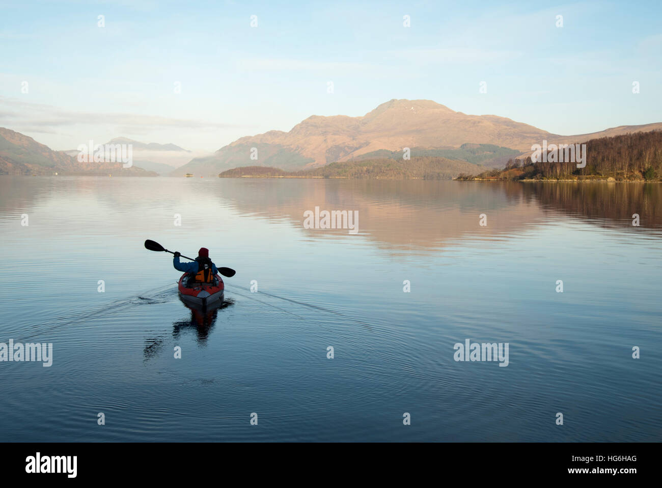 Loch Lomond and The Trossachs National Park, Scotland, UK. 5th January 2017. High pressure brings cold calm conditions to Loch Lomond, with kayaker paddling in front of Scotland's most southerly munro mountain (Ben Lomoond) Stock Photo