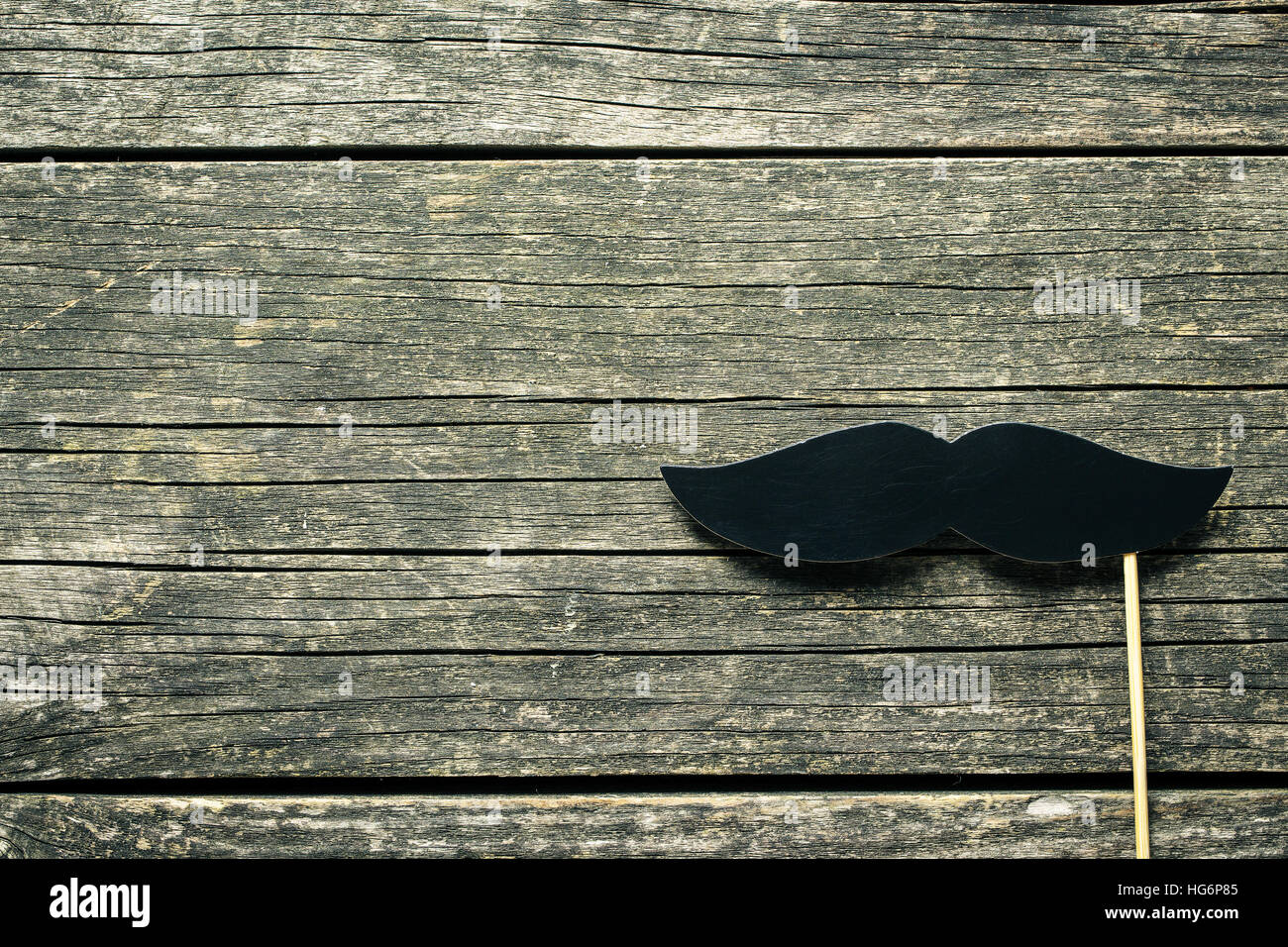 Fake black mustache on old wooden background. Stock Photo