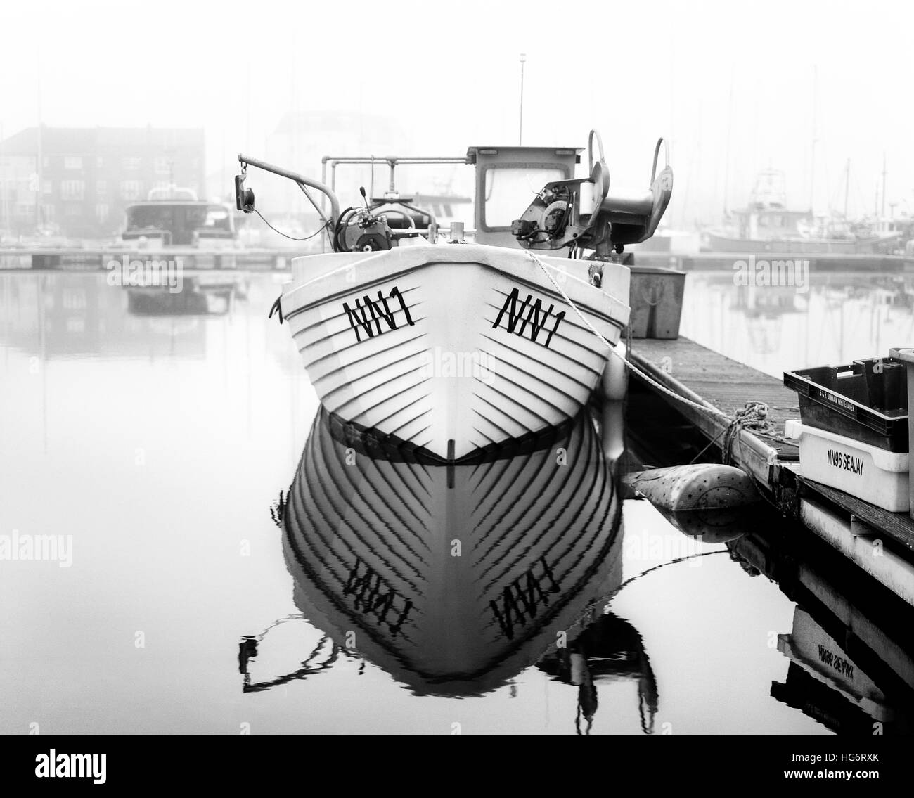 Black and white photo of a boat moored in a local harbour Stock Photo