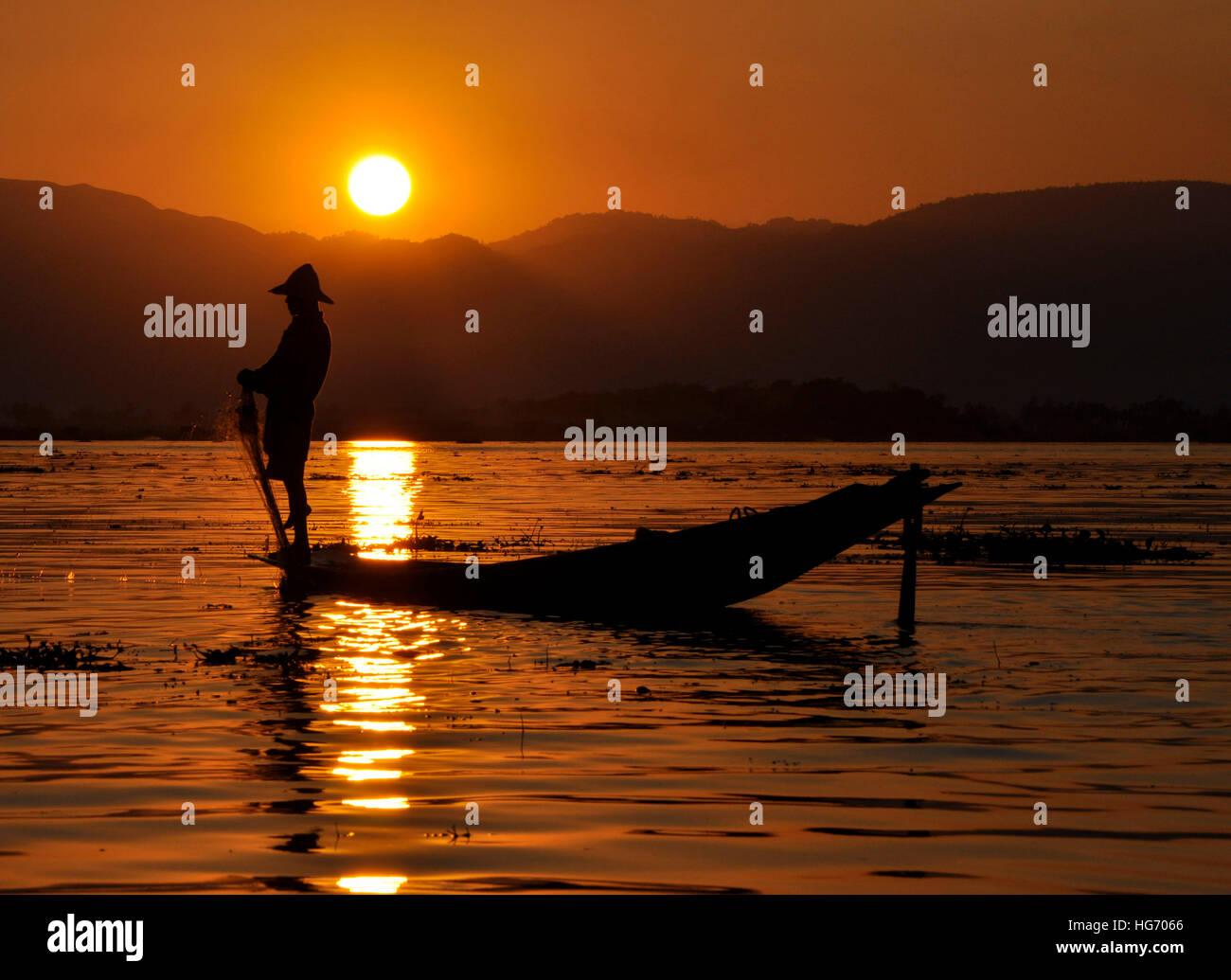 Silhouette of a fisherman in the sunset at Inle lake in Burma Stock Photo