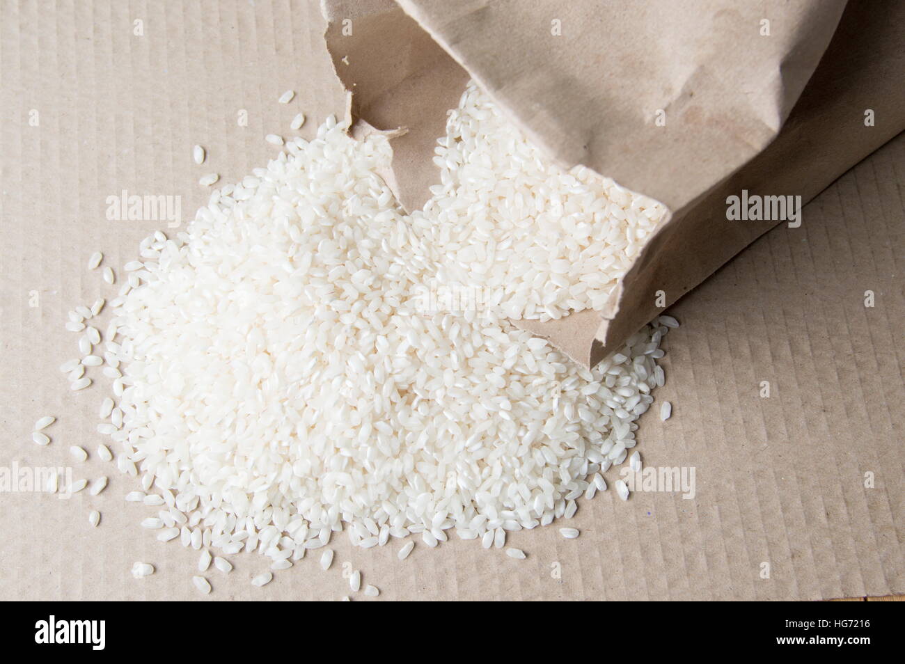 Rice falling out of big paper bag Stock Photo