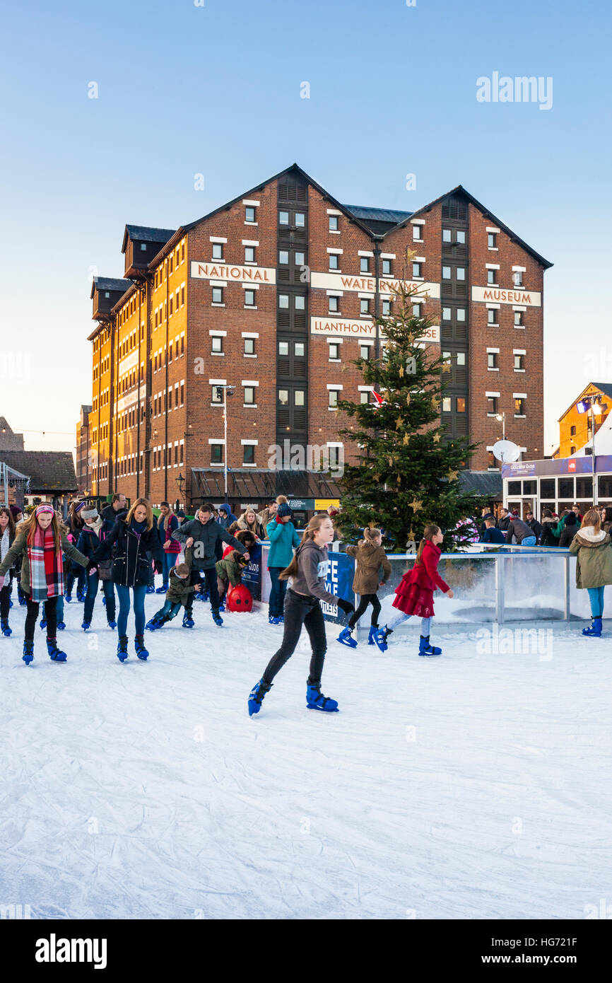 A temporary seasonal open air ice rink for Christmas and the New Year at Gloucester Quays, Gloucestershire UK Stock Photo