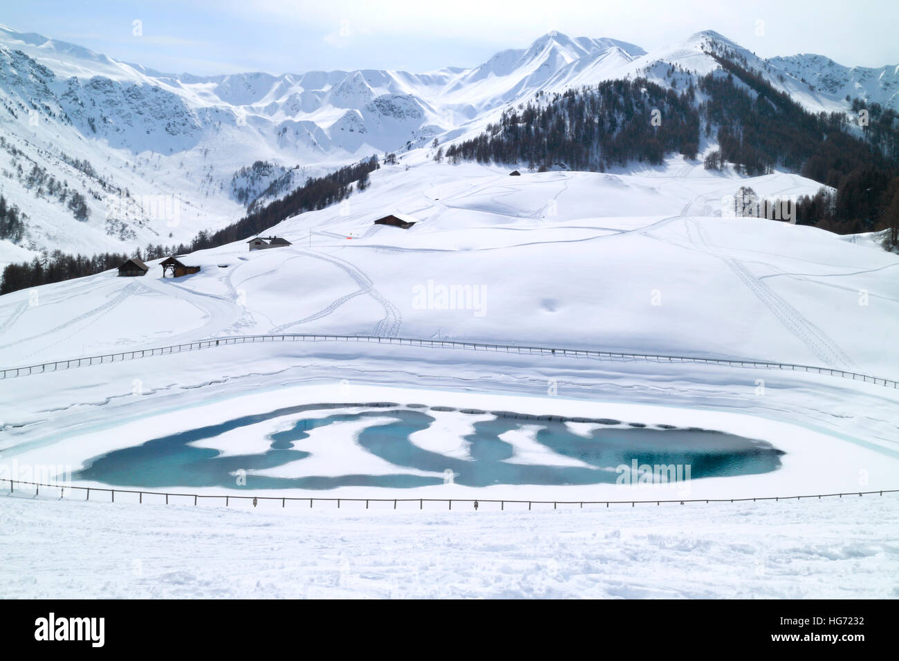 Frozen lake on top of mountains by downhill skiing slopes, Les Arcs, French Alps Stock Photo