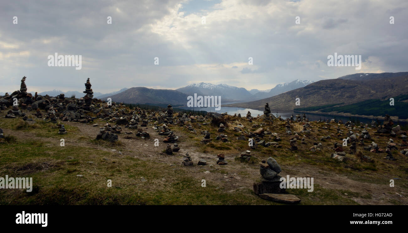 Scenic view of mini cairns at loch loyne Skye. Sun rays and mountains in the background. Stock Photo