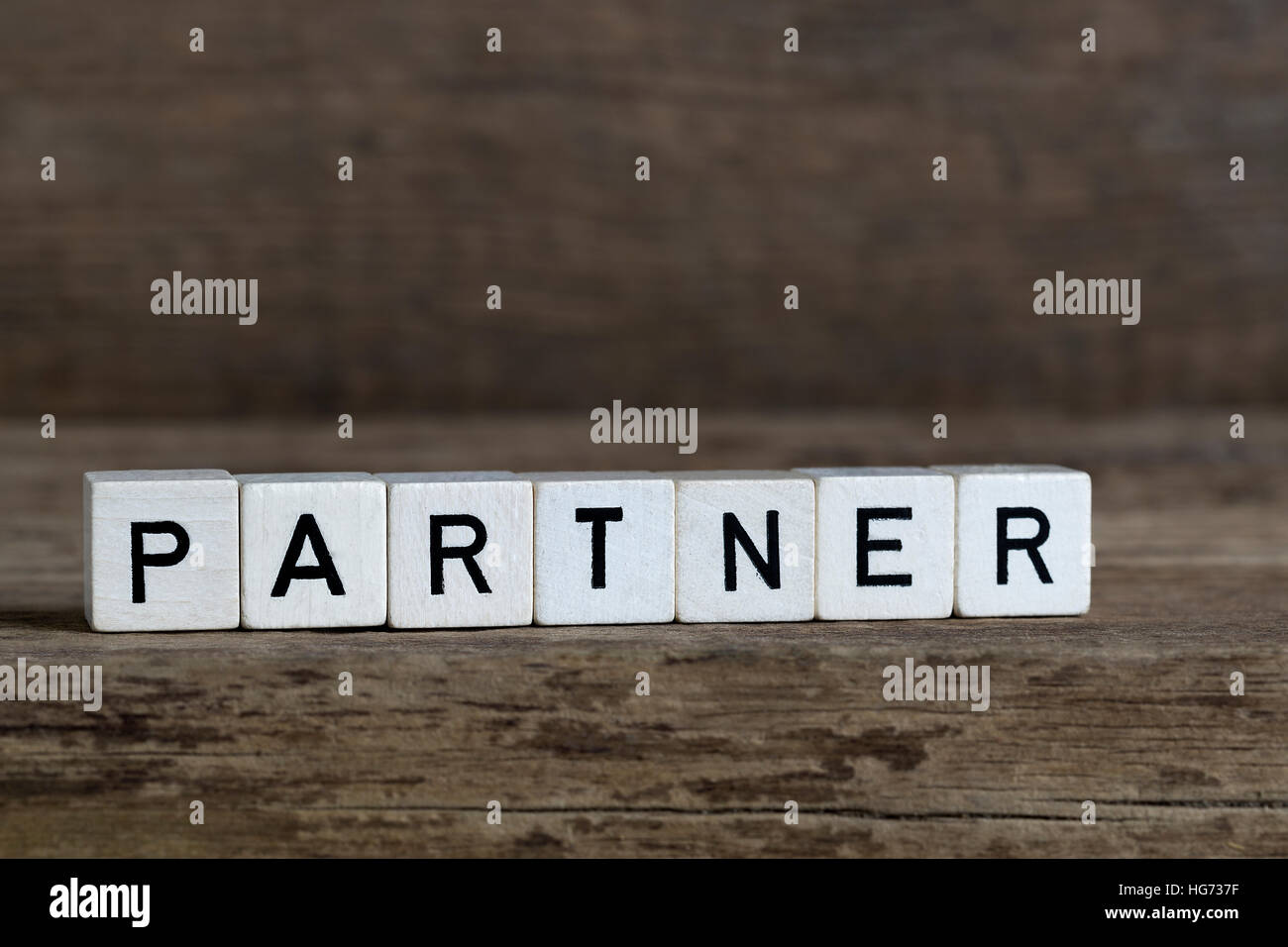 Partner, written in cubes on wooden background Stock Photo