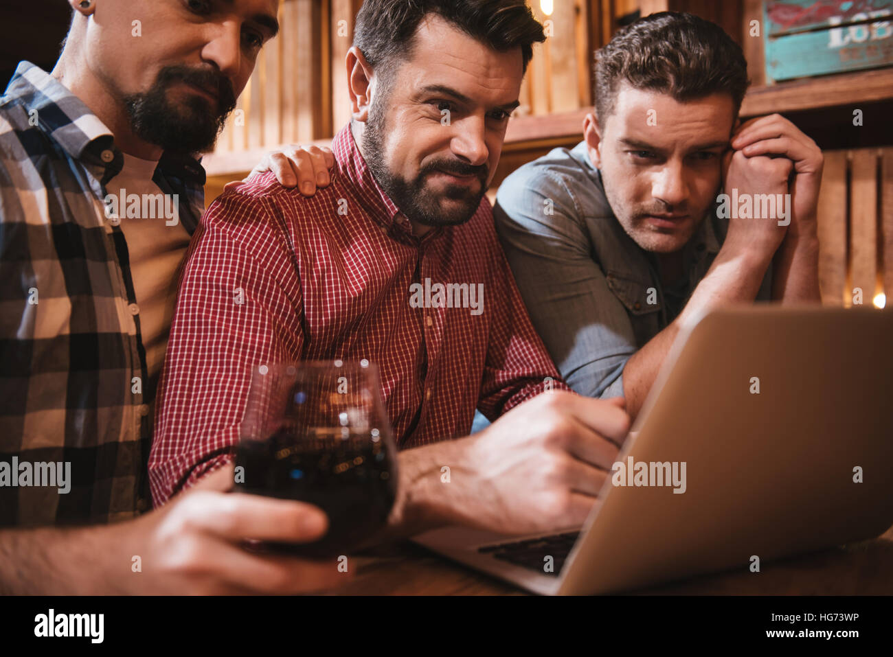 Nice pleasant group of friends sitting at the laptop Stock Photo