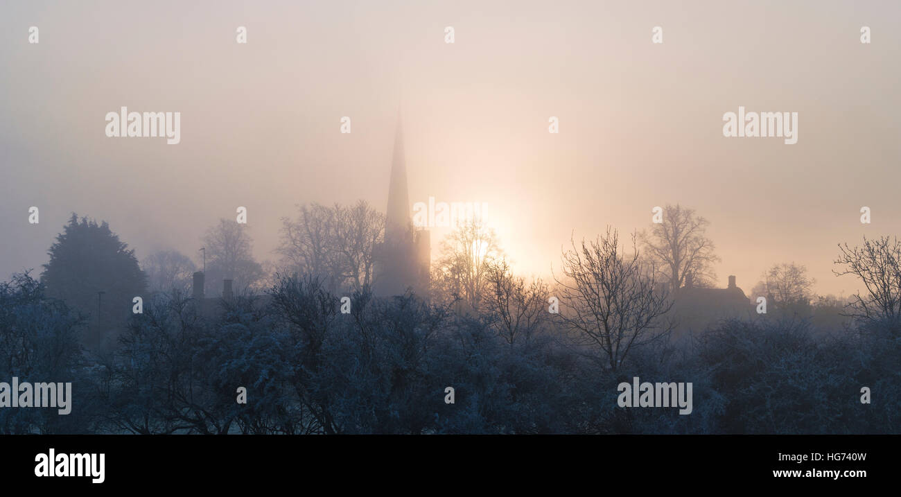 Burford Church in thick frosty fog at sunrise in winter. Burford, Cotswolds, Oxfordshire, England Stock Photo