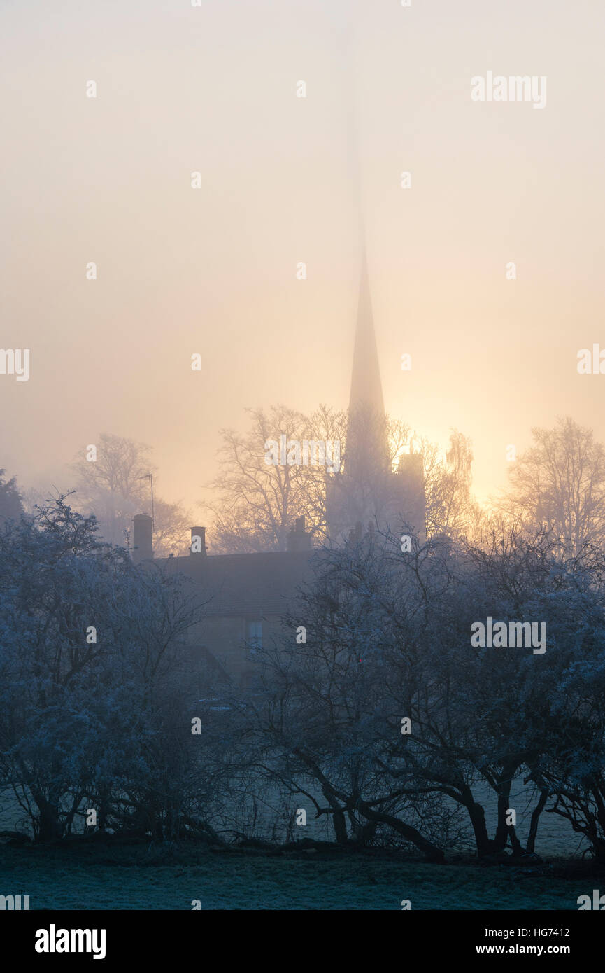 Burford Church in thick frosty fog at sunrise in winter. Burford, Cotswolds, Oxfordshire, England Stock Photo