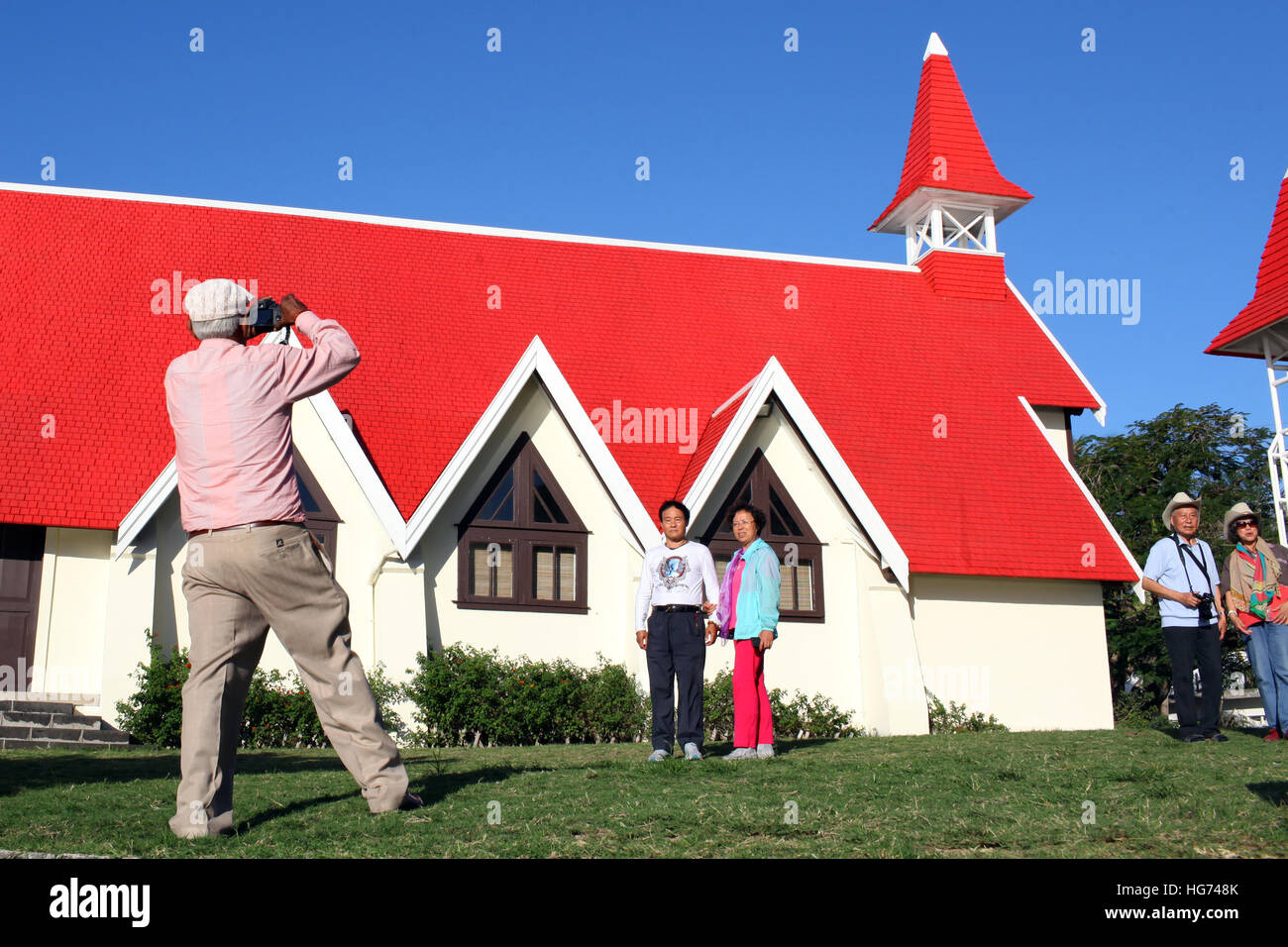 Japanese tourists photograph Notre Dame Auxiliatrice Cap Malheureux Stock Photo