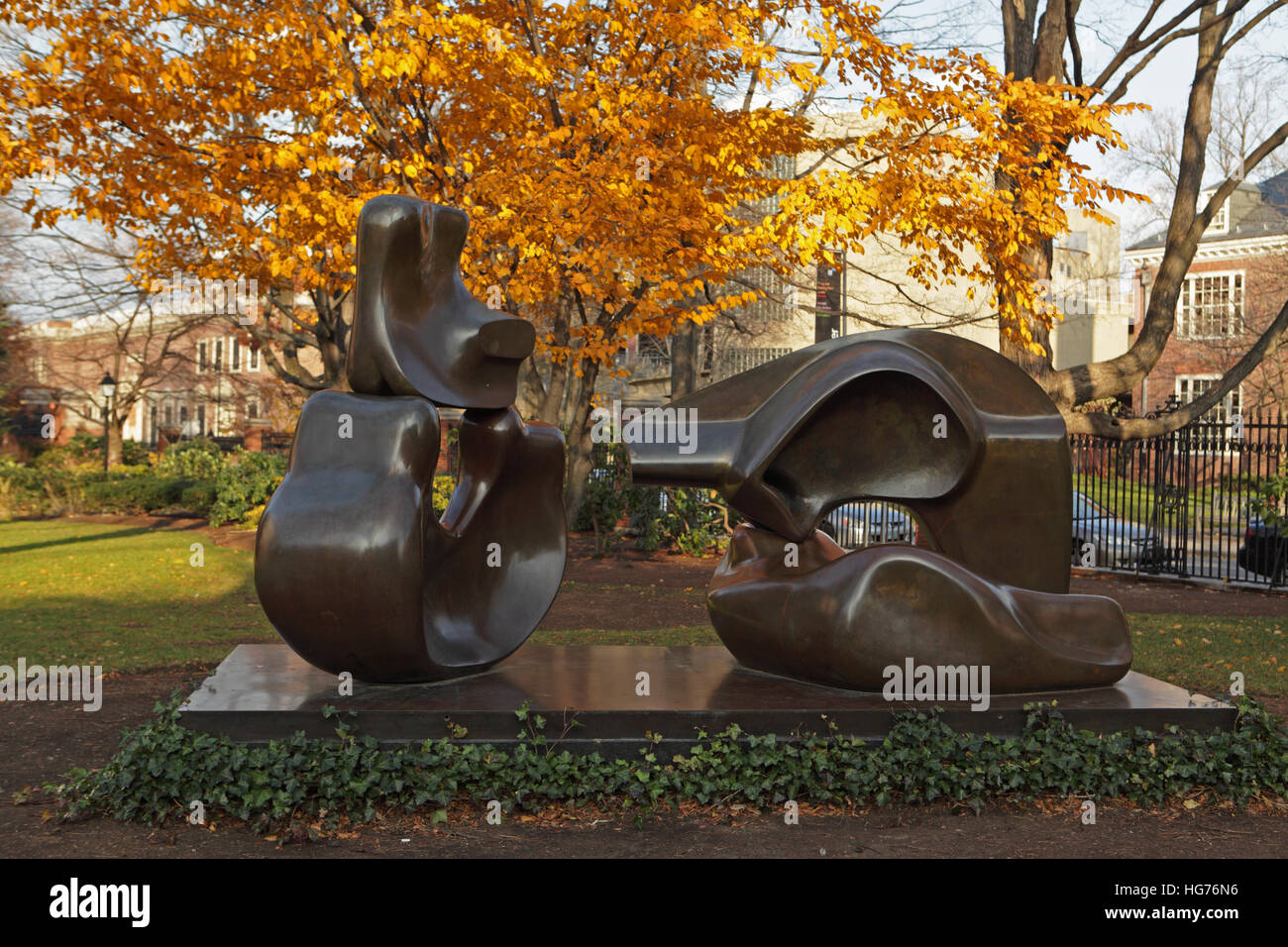 Harvard University campus on an autumn morning. Statue by Henry Moore entitled Four Piece Reclining Figure outside the Lamont Library. Stock Photo