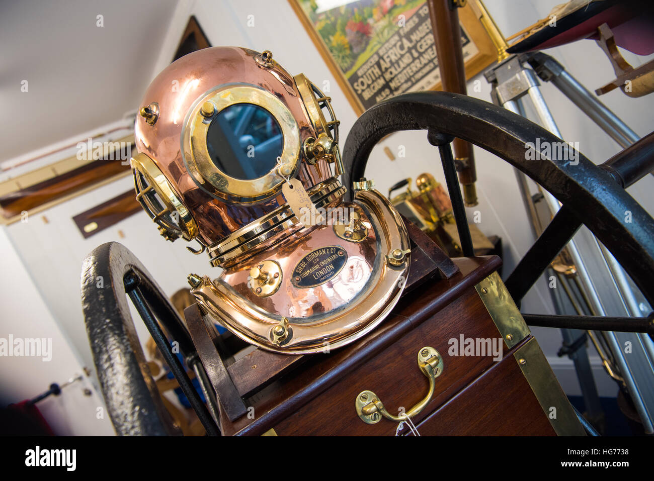 Vintage deep sea diving helmet in brass and copper and mechanical breathing apparatus on sale in an upmarket antique shop Stock Photo