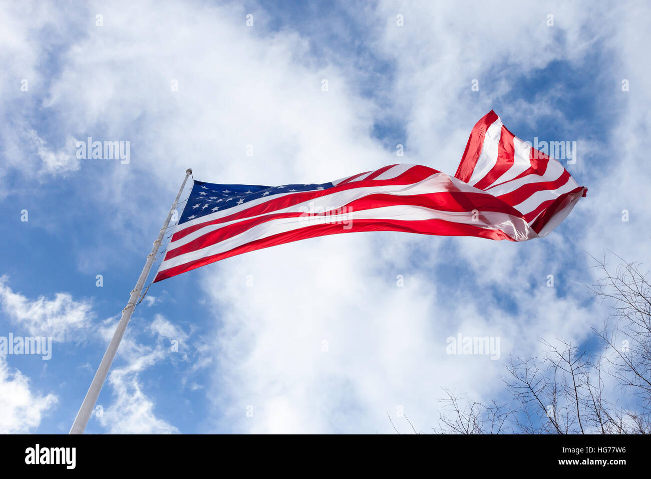 An American Flag blows in the wind with a beautiful sky Stock Photo