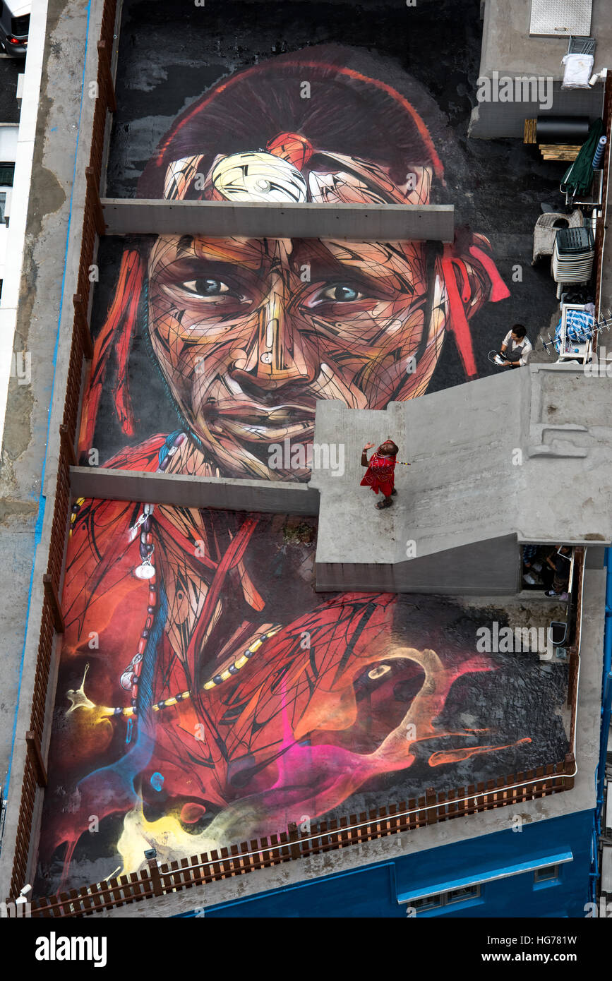 Rooftop painting by Parisian street artist Alexandre Monteiro aka Hopare of Masai warrior Daniel Ole Sambu (pictured) with photographer Sean Lee-Davie Stock Photo