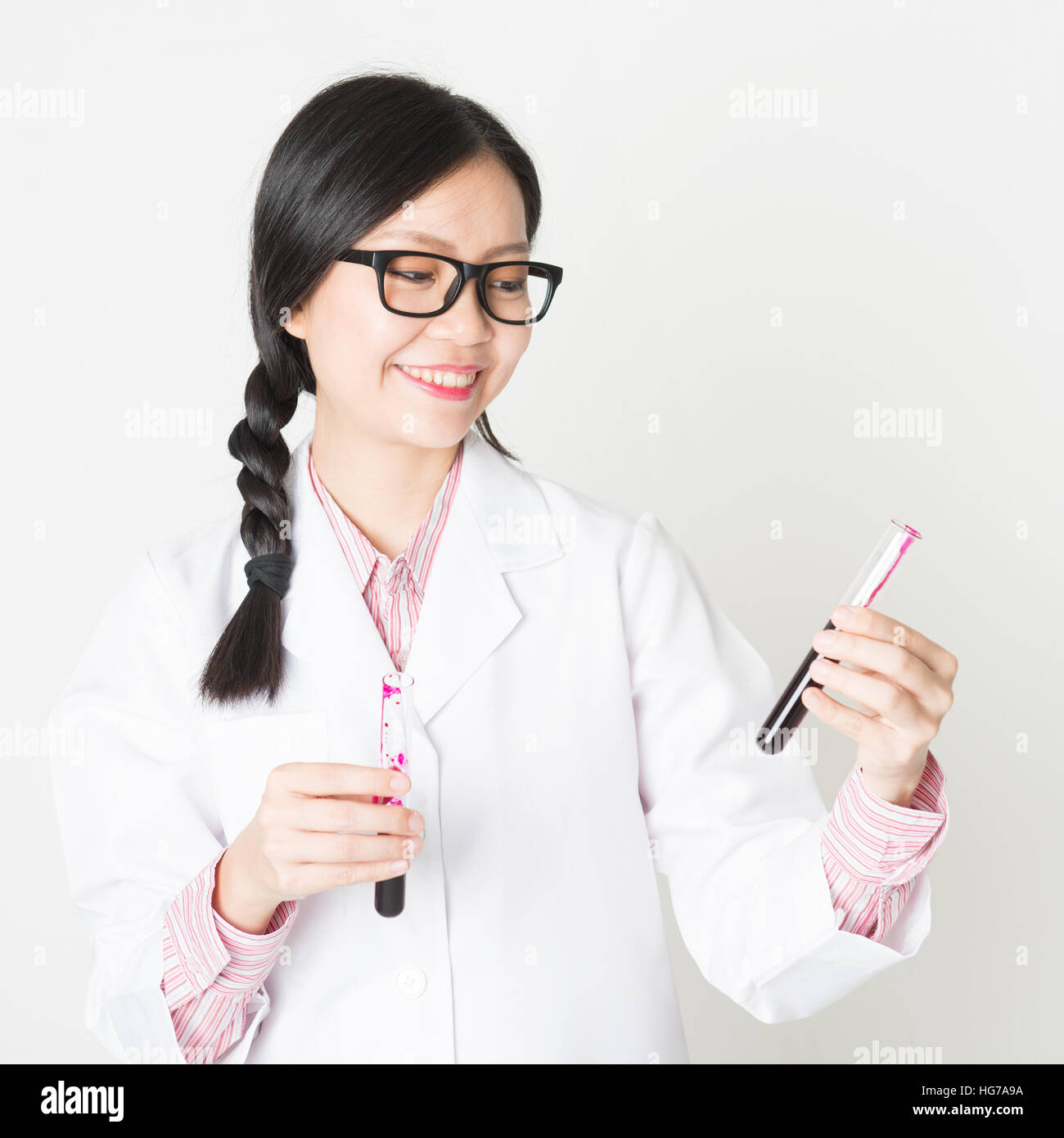Young attractive laboratory assistant checking the blood in tube, portrait shot of a female scientist. Stock Photo
