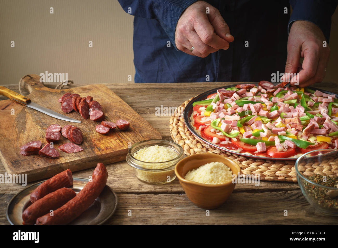 Man in a blue shirt makes homemade pizza in the kitchen horizontal Stock Photo
