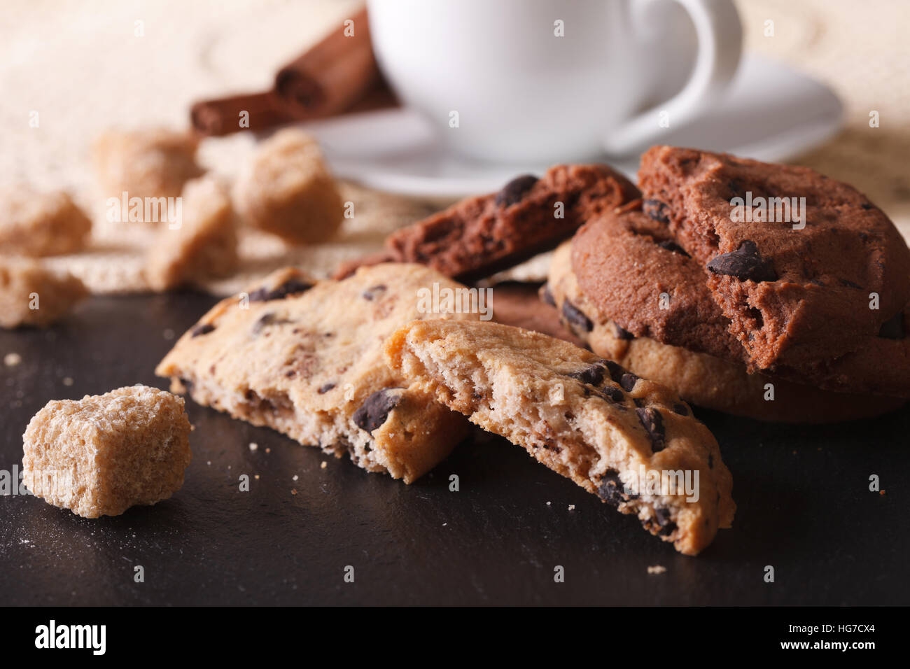 Tasty chocolate chips cookies and a piece of sugar cane on the table macro. horizontal Stock Photo