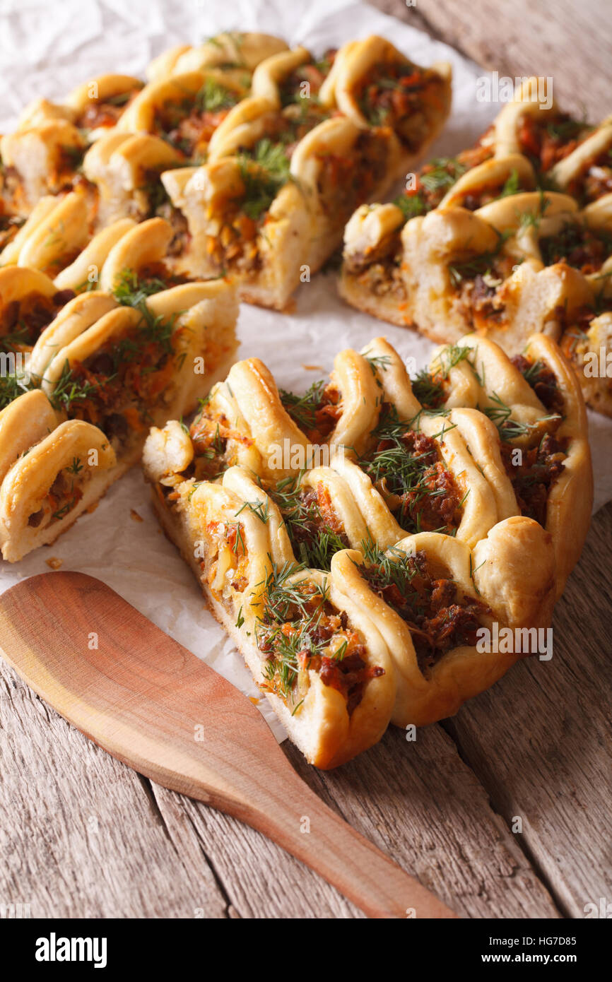 Cut open pie with meat and vegetables closeup on the table. Vertical