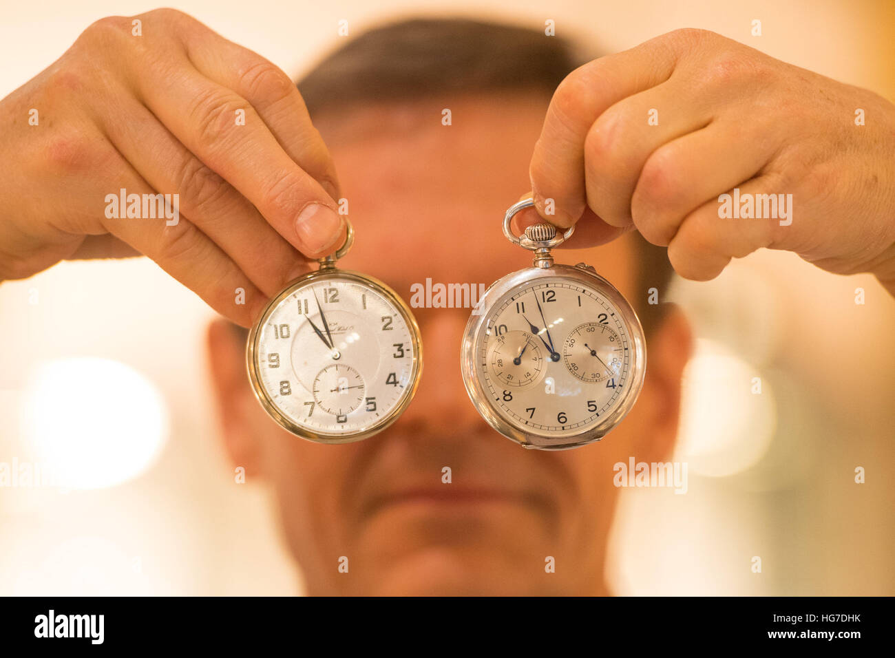 An exhibitor holds a Kriegsmarine WWII German Navy U-Boat deck watch, valued at &Acirc;£4,600, (left) and a A Lange & Sohne WWII German navy watch, valued at &Acirc;£9,800, at the Mayfair Antiques and Fine Art Fair at the London Marriott Hotel, in London. Stock Photo